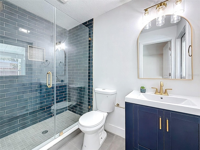 bathroom featuring vanity, toilet, a stall shower, and a textured ceiling