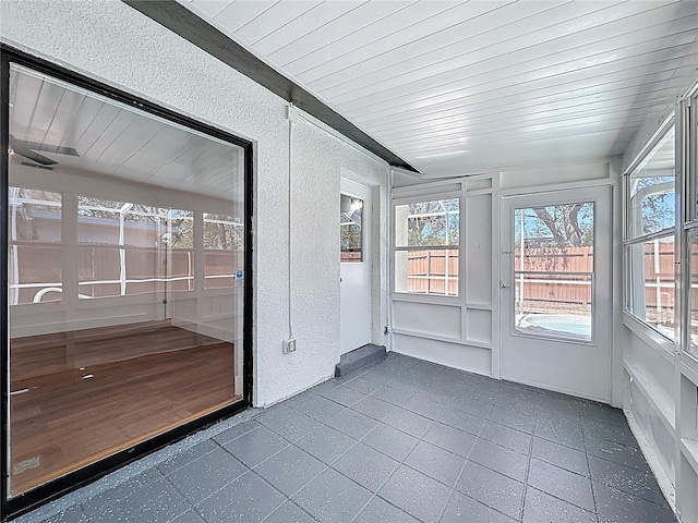 unfurnished sunroom with wood ceiling