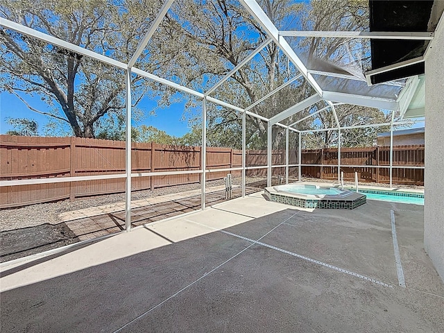 view of patio featuring a lanai, a fenced backyard, and a pool with connected hot tub