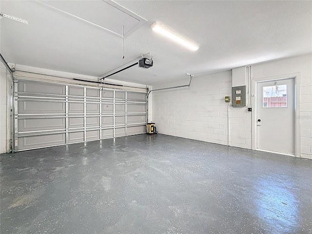 garage with electric panel, concrete block wall, and a garage door opener