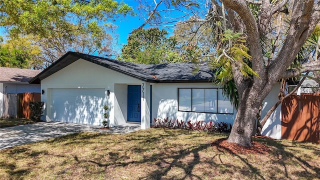 ranch-style house with fence, driveway, an attached garage, stucco siding, and a front lawn