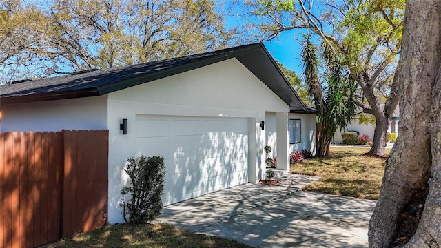 exterior space featuring concrete driveway and fence