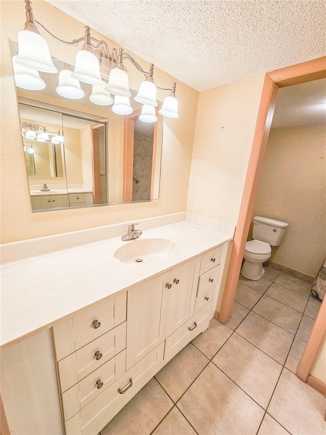 bathroom with tile patterned floors, a textured ceiling, vanity, and toilet