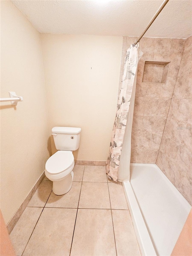 full bathroom featuring a textured ceiling, toilet, a stall shower, and tile patterned flooring