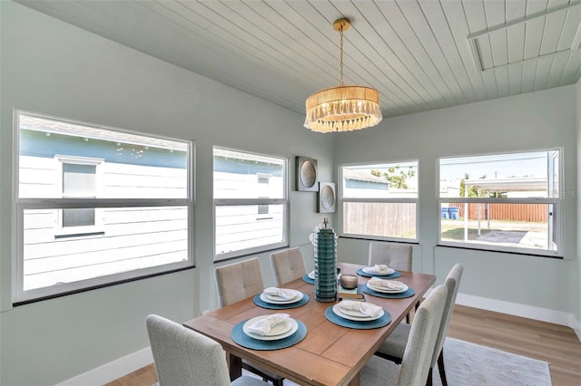 dining room featuring an inviting chandelier, wooden ceiling, baseboards, and wood finished floors