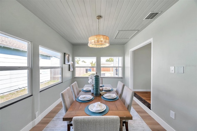 dining area with visible vents, a notable chandelier, wood finished floors, baseboards, and wood ceiling