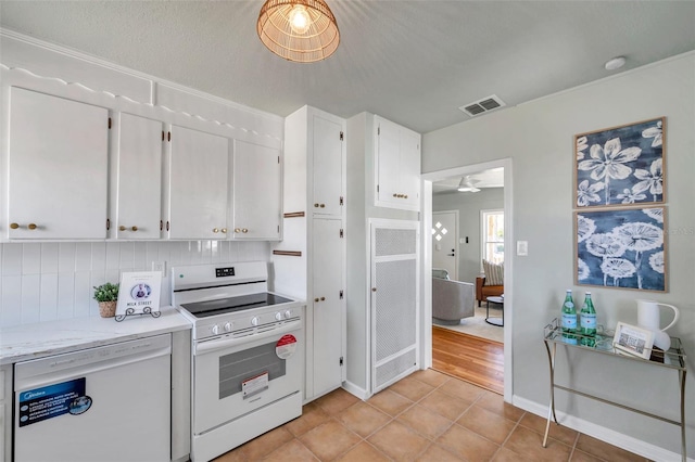 kitchen with visible vents, white cabinetry, white appliances, light tile patterned floors, and decorative backsplash