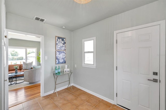 entryway featuring visible vents, plenty of natural light, baseboards, and light tile patterned flooring