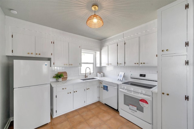 kitchen featuring white appliances, white cabinetry, light countertops, and a sink