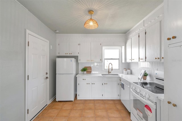 kitchen with white appliances, white cabinets, light countertops, and a sink