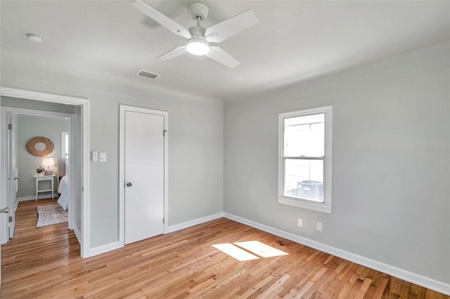 unfurnished bedroom featuring a ceiling fan, baseboards, visible vents, light wood finished floors, and a closet