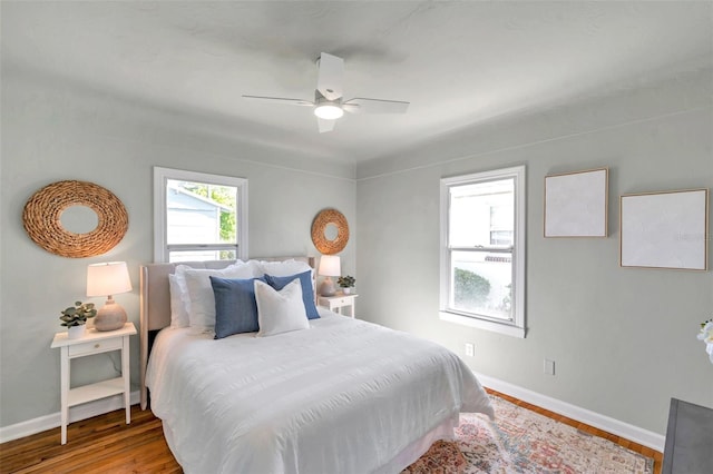 bedroom featuring ceiling fan, baseboards, and wood finished floors