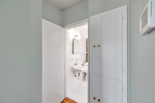 bathroom with tile walls and a sink