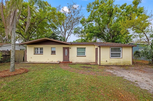 single story home with a front lawn and fence