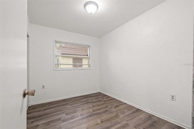 empty room featuring baseboards and wood finished floors