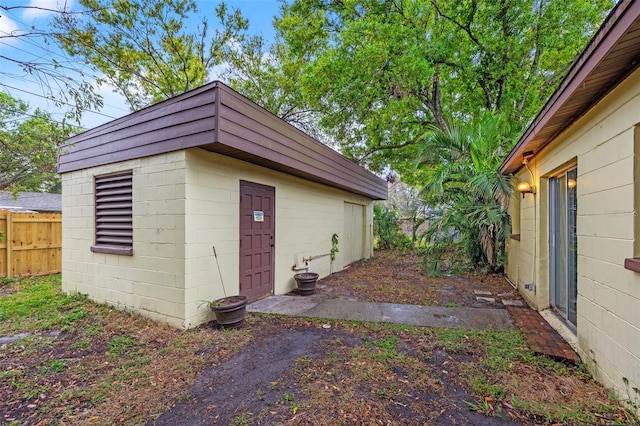 view of outbuilding featuring an outdoor structure and fence