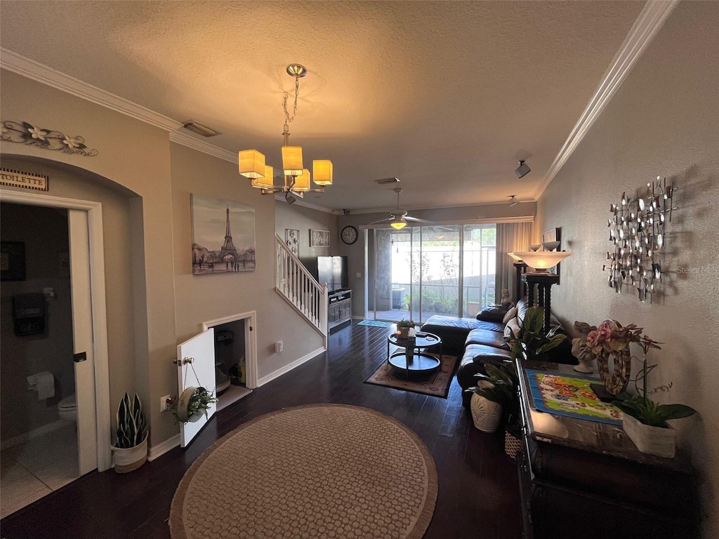 living room with visible vents, crown molding, stairs, wood finished floors, and a textured ceiling