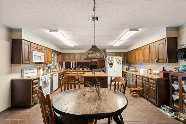 dining space featuring visible vents, baseboards, and brick floor