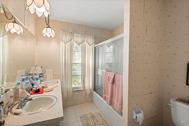 full bathroom with wallpapered walls, a sink, tile patterned floors, toilet, and combined bath / shower with glass door