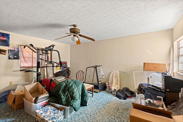 interior space featuring carpet flooring, a textured ceiling, and ceiling fan