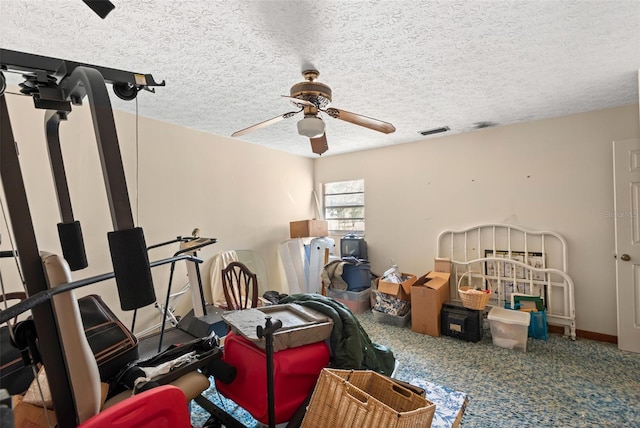 exercise room featuring visible vents, a textured ceiling, and a ceiling fan