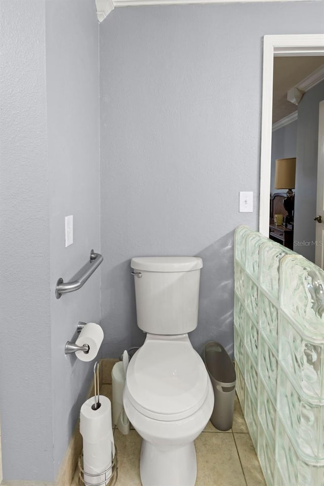 bathroom with tile patterned floors, toilet, and ornamental molding