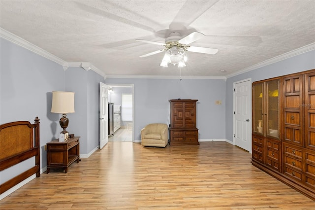 sitting room featuring light wood-type flooring, a textured ceiling, and crown molding