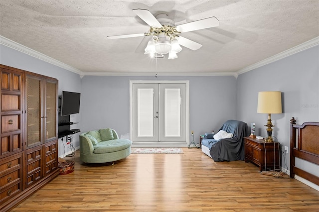 sitting room featuring crown molding, french doors, light wood-type flooring, and a textured ceiling