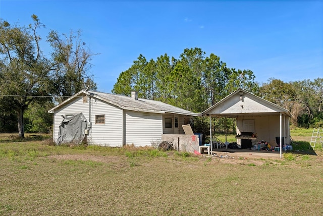 exterior space with an attached carport and a yard