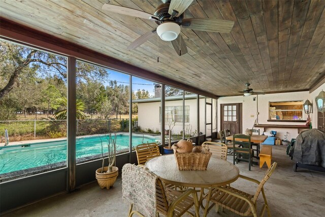 sunroom / solarium with wooden ceiling, a wealth of natural light, and ceiling fan