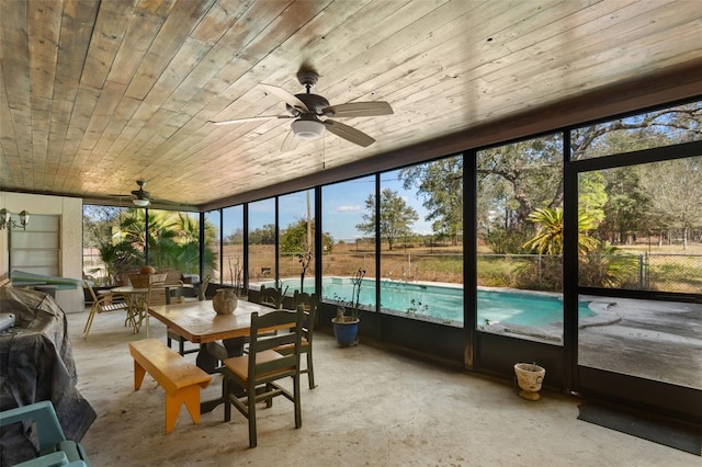 unfurnished sunroom featuring wood ceiling and ceiling fan