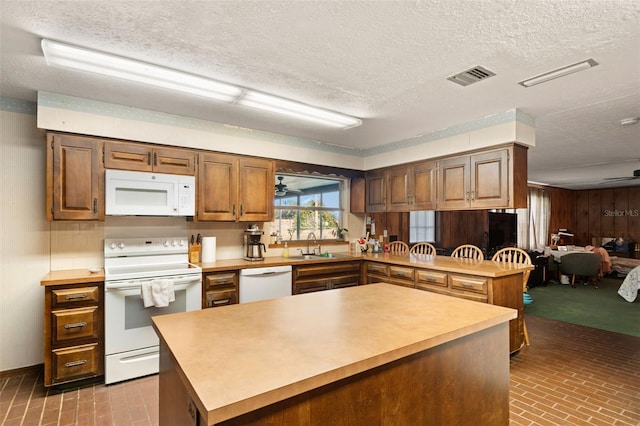 kitchen with brick floor, visible vents, white appliances, and light countertops