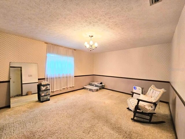11327 Carter Grove Ln, Thonotosassa, FL 33592 - unfurnished room with wallpapered walls, a chandelier, a textured ceiling, and carpet