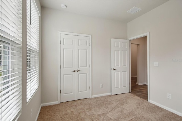 45 Perkins Ln, Palm Coast, FL 32164 - unfurnished bedroom with a closet, carpet flooring, visible vents, and baseboards