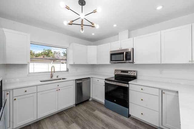 kitchen with a sink, a notable chandelier, white cabinetry, and stainless steel appliances