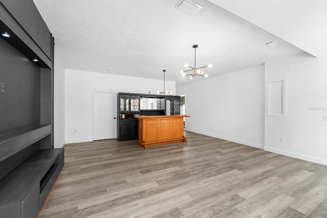 bar featuring an inviting chandelier, refrigerator, visible vents, and light wood-type flooring