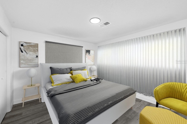 bedroom featuring visible vents, baseboards, and wood finished floors