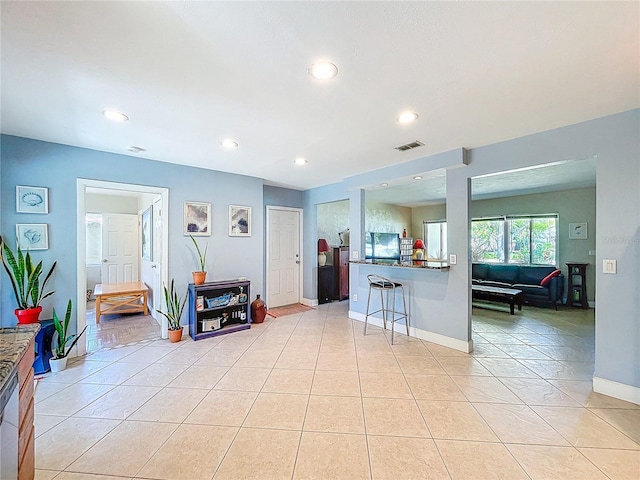 kitchen with dishwashing machine, light tile patterned floors, visible vents, recessed lighting, and a kitchen bar