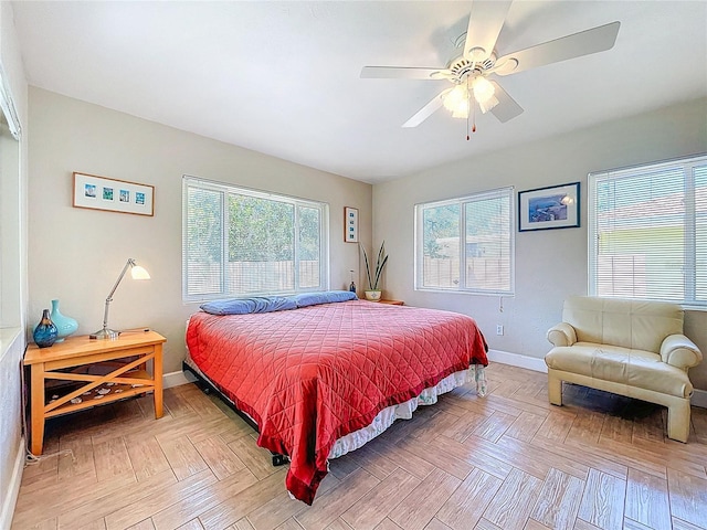 bedroom featuring baseboards, multiple windows, and ceiling fan