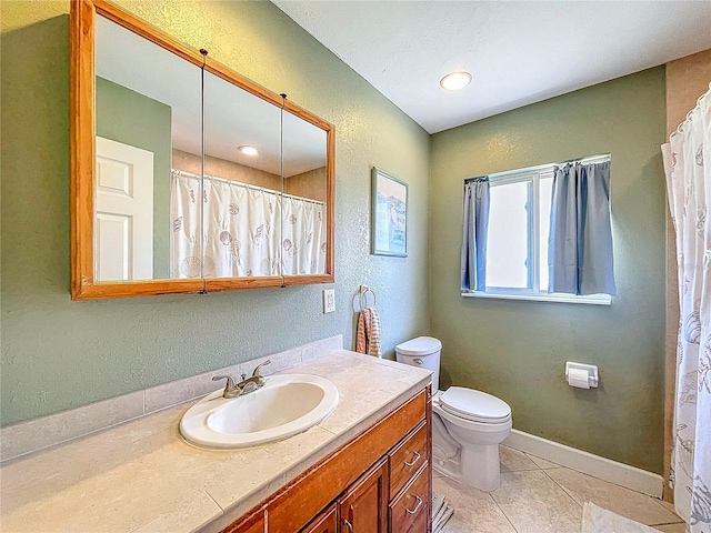 full bathroom with baseboards, toilet, a textured wall, tile patterned floors, and vanity