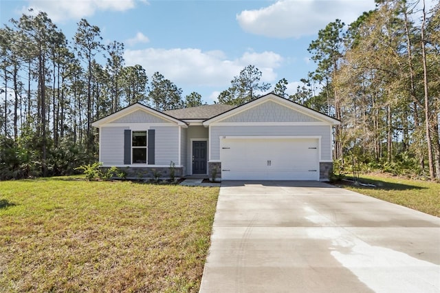 view of front of home with a front lawn, stone siding, a garage, and driveway