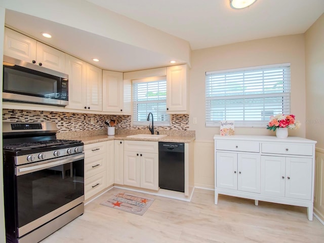 kitchen featuring a sink, white cabinets, tasteful backsplash, and stainless steel appliances