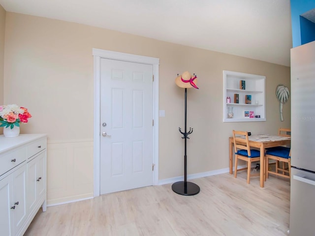 interior space featuring a wainscoted wall and light wood-type flooring