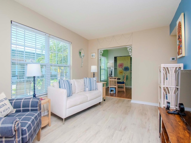 living area featuring baseboards and light wood-style floors