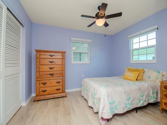 bedroom with a closet, baseboards, ceiling fan, and light wood finished floors