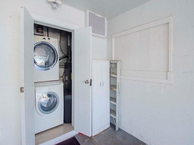 laundry area featuring laundry area, visible vents, and stacked washing maching and dryer