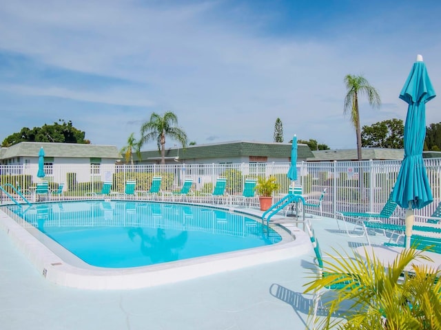 pool with a patio and fence