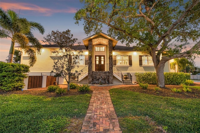 view of front of property featuring a lawn and stucco siding