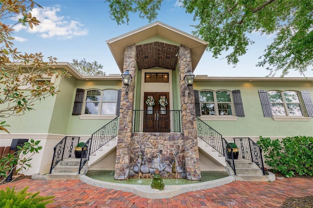 entrance to property with stucco siding and stone siding