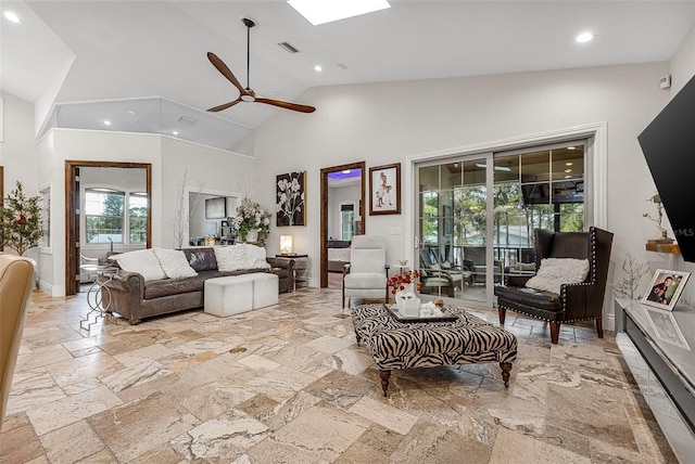 living room with visible vents, high vaulted ceiling, stone tile floors, a skylight, and baseboards